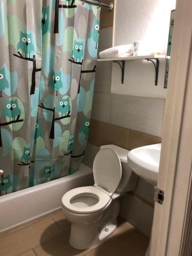 uma casa de banho com um WC e uma cortina de chuveiro em Lombardy Inn Hotel em Miami Beach