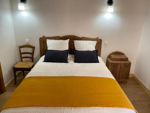 um quarto com uma cama grande e um cobertor amarelo em Clos De La Charnaille em Cousance