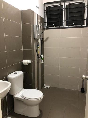 a bathroom with a toilet and a sink at The Crib @ Desaru in Desaru