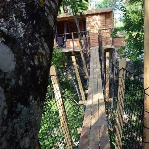 a fence in front of a house with a tree at Les Cabanes de Brassac in Brassac