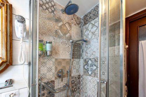 a shower in a bathroom with a glass shower stall at Kyterion Apartment in Rome