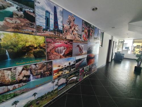 a wall with pictures of different places on it at Hotel Royal Plaza in Villavicencio
