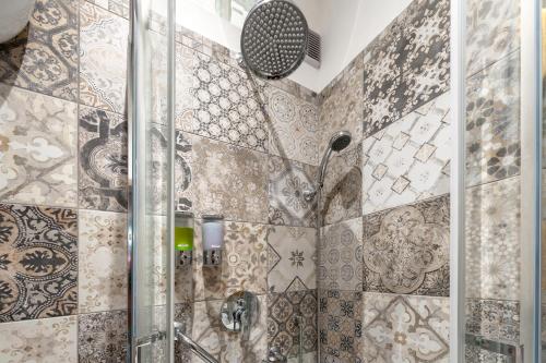 a bathroom with a shower with tiles on the wall at Kyterion Apartment in Rome