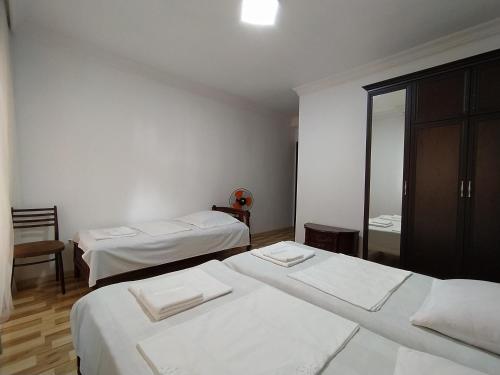 a white room with two beds and a mirror at Guest House TeNi in Makhinjauri