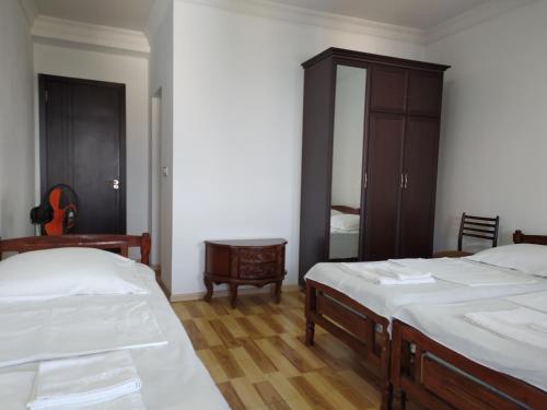 a bedroom with two beds and a dresser at Guest House TeNi in Makhinjauri