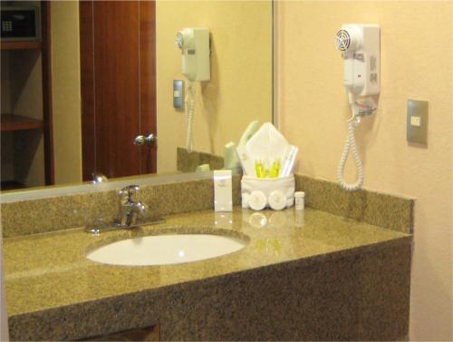 a bathroom counter with a sink and a phone at Hotel Soleil Celaya in Celaya