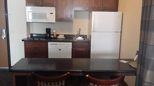 a kitchen with a white refrigerator and a counter top at American Inn & Suites in Parkers Prairie