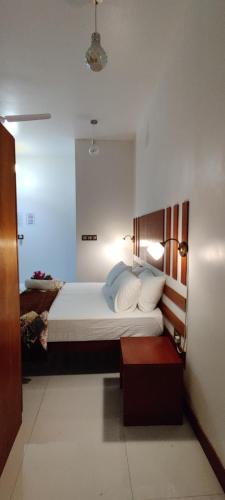 FuvahmulahにあるEquator Holiday Innのベッドルーム1室(大型ベッド1台、白いシーツ、枕付)