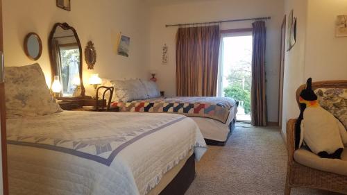 um quarto de hotel com duas camas e um pinguim sentado numa cadeira em Yosemite Plaisance Bed & Breakfast em Mariposa