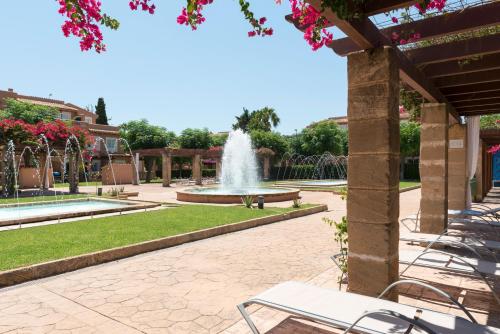 einen Brunnen inmitten eines Parks in der Unterkunft Aparthotel Ciudad Laurel in Cala Millor