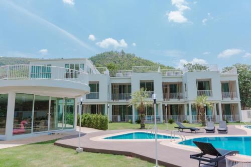 a large white building with a swimming pool at Erachon Raft Resort in Kanchanaburi