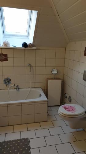 ein Bad mit einer Badewanne, einem WC und einem Fenster in der Unterkunft Melle Ferienwohnung in Melle