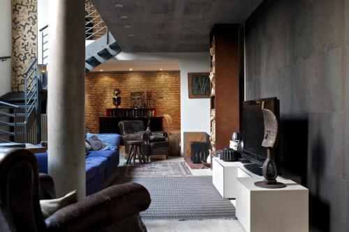 sala de estar con sofá azul y TV en B&B Design, en Bolonia