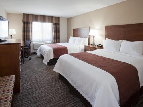 a hotel room with two beds and a television at American Inn & Suites in Parkers Prairie