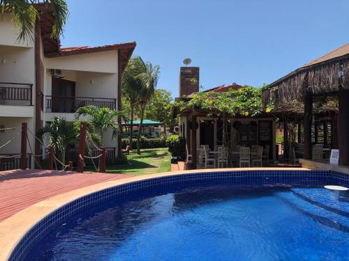 a swimming pool in front of a house at Kanaloa Pousada in Jericoacoara