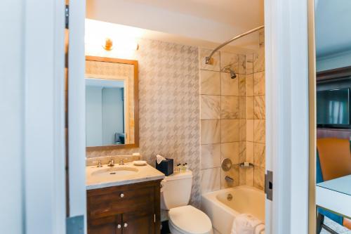 a bathroom with a toilet and a tub and a sink at Dunhill Hotel in Charlotte