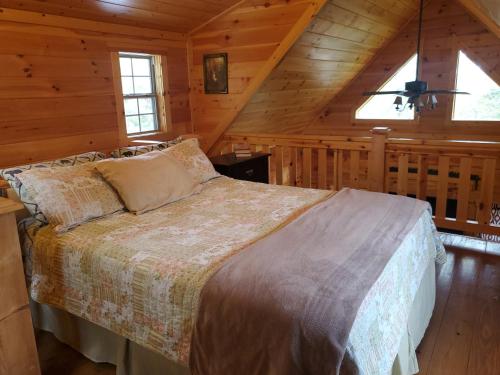 um quarto com uma cama num camarote em The Hampton - An Amish Built Deluxe Log Cabin em Genoa