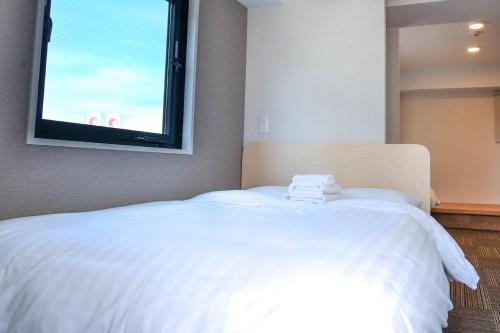 a bedroom with a large white bed with a window at The Light Inn - Vacation STAY 94706 in Tokyo