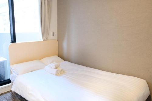 een slaapkamer met een bed met twee handdoeken erop bij The Light Inn - Vacation STAY 94702 in Tokyo