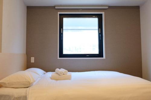 a bedroom with a bed with two towels on it at The Light Inn - Vacation STAY 94706 in Tokyo