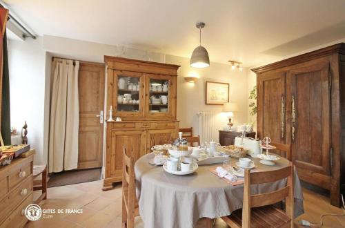 een eetkamer met een tafel met gerechten erop bij Les Chambres du Chataignier in Léry