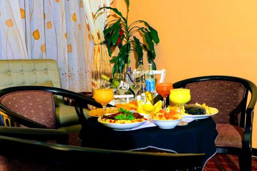 a table topped with plates of food and drinks at Keba Guesthouse in Addis Ababa