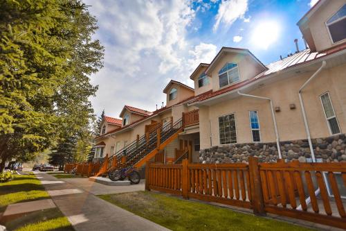 a house with a wooden fence in front of it at Riverside by FantasticStay in Fernie