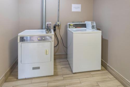 a kitchen with a stove and a machine in a room at BridgePointe Inn & Suites by BPhotels, Council Bluffs, Omaha Area in Council Bluffs