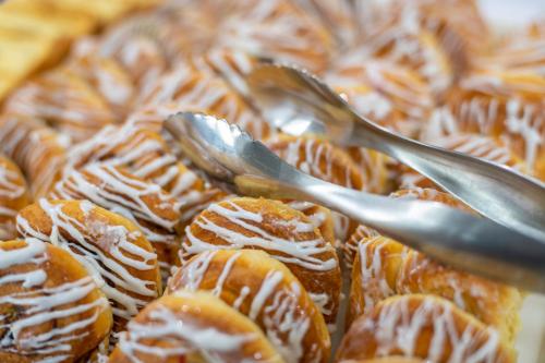 a pile of pastries with silver spoons in them at BridgePointe Inn & Suites by BPhotels, Council Bluffs, Omaha Area in Council Bluffs