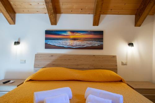 a bedroom with a bed with two white chairs at Grazie papà - The beginning of the path of the gods in Pianillo