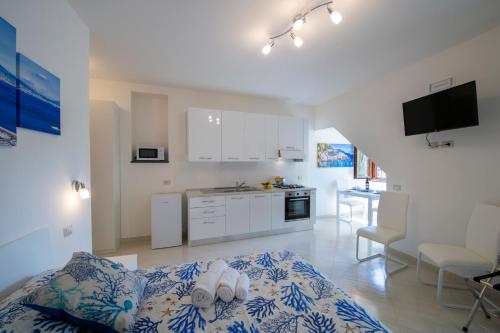 a white kitchen with a bed in a room at Grazie papà - The beginning of the path of the gods in Pianillo