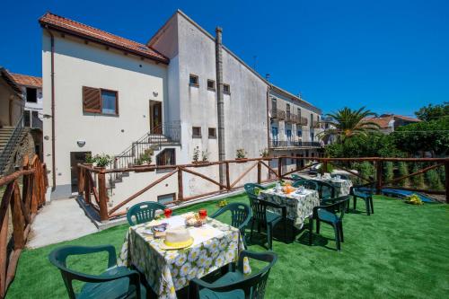 a patio with tables and chairs on the grass at Grazie papà - The beginning of the path of the gods in Pianillo