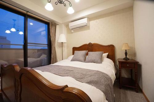 a bedroom with a bed and a large window at GRADIA Koenji - Vacation STAY 95233 in Tokyo