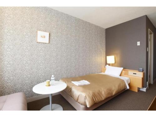 una camera d'albergo con letto e tavolo di Hotel Grand Vert Gizan - Vacation STAY 95360 a Gifu