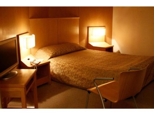 um quarto com uma cama, 2 candeeiros e uma televisão em Hotel Grand Vert Gizan - Vacation STAY 95357 em Gifu