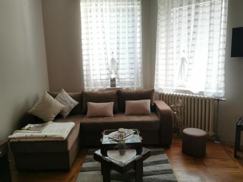 a living room with a brown couch and a table at Kata's Place in Subotica
