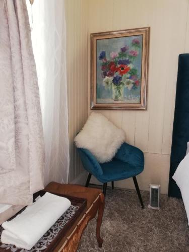 a room with a blue chair and a painting at Richmond Hill Guest House in Port Elizabeth