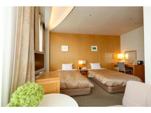 um quarto de hotel com duas camas e uma televisão em Hotel Grand Vert Gizan - Vacation STAY 95355 em Gifu