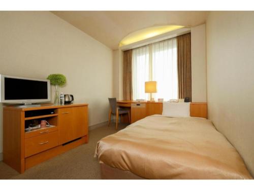 a bedroom with a bed and a desk with a television at Hotel Grand Vert Gizan - Vacation STAY 95353 in Gifu