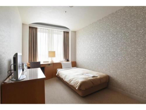 a bedroom with a bed and a desk and a television at Hotel Grand Vert Gizan - Vacation STAY 95353 in Gifu
