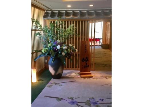 a vase filled with flowers in a hallway at Hotel Grand Vert Gizan - Vacation STAY 95368 in Gifu