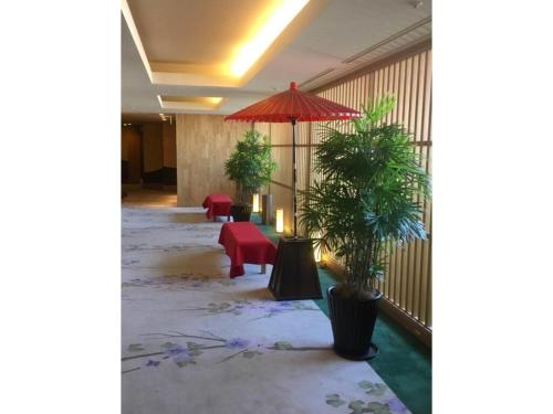 a lobby with plants and a red umbrella at Hotel Grand Vert Gizan - Vacation STAY 95368 in Gifu