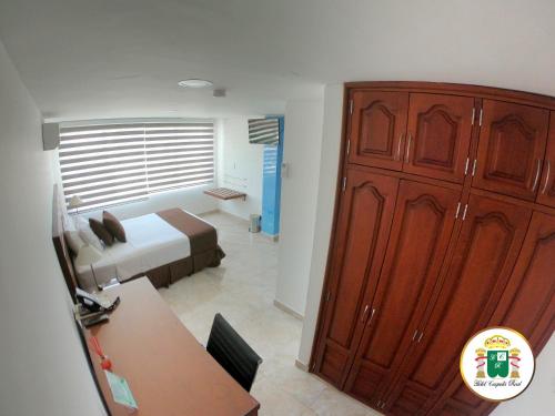 a bedroom with a bed and a large wooden cabinet at Hotel Caquetá Real HSC in Florencia