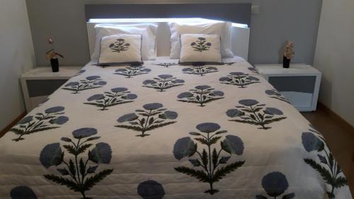 - un lit avec une couverture et des oreillers bleus et blancs dans l'établissement Mira Serras, à Vouzela