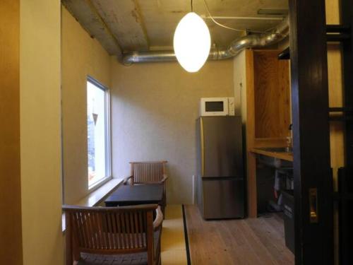 een keuken met een koelkast en een tafel en stoelen bij New Art Building - Vacation STAY 95699 in Tokyo