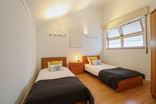 1 dormitorio con 2 camas y ventana en Central Apartment - Viana City Centre, en Viana do Castelo