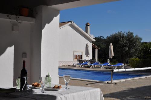a table with a bottle of wine and glasses next to a pool at Casal do Morgado, country house to relax in Formigais