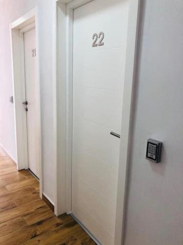 a hallway with two white doors and a clock on the wall at ALPIN rooms in Topliţa