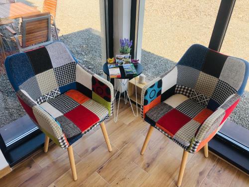 two chairs and a table in a room at ALPIN rooms in Topliţa