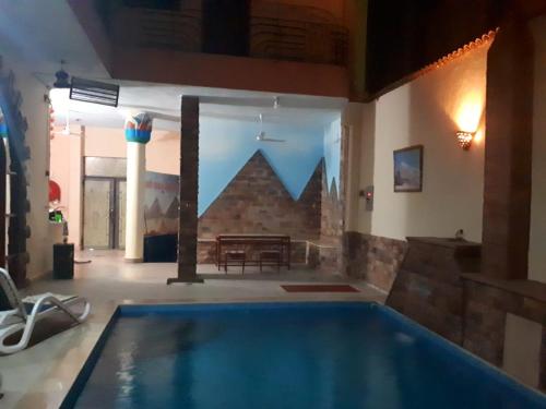 a large swimming pool in a room with a table at Pyramids Luxor Hotel & SPA in Luxor